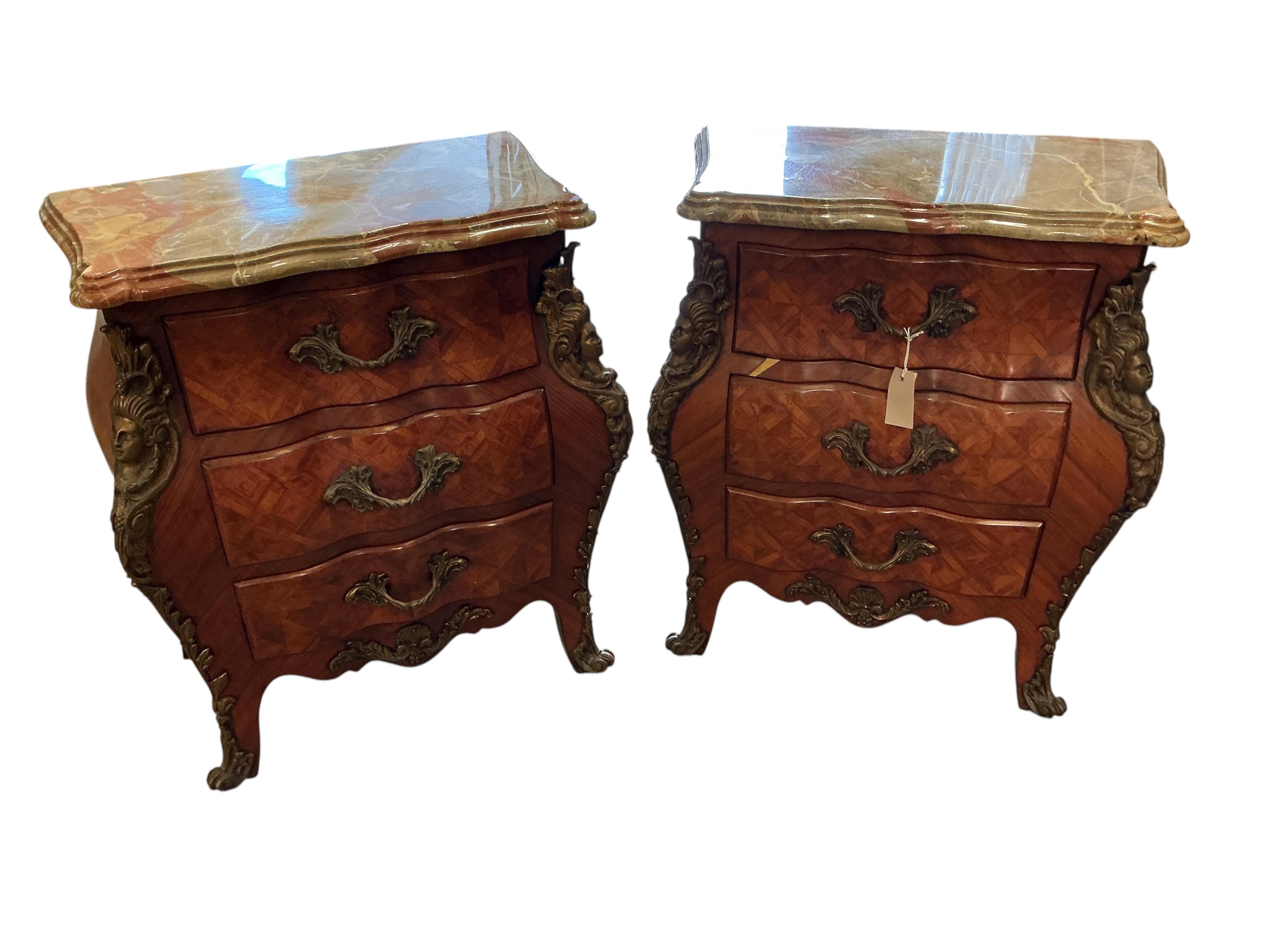 A pair of French transitional style bombe gilt metal mounted onyx top three drawer bedside chests, width 61cm, depth 33cm, height 71cm